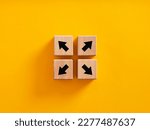 Small photo of Decision making and choosing the right path. Dysfunctional team, diversity and opposition. Team disunity and separation. Arrow icons on wooden cubes moving to opposite directions.