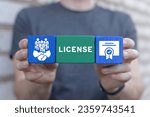 Small photo of Man holding colorful styrofoam blocks with icons and text: LICENSE. Licensing. License agreement business technology concept. Copyright protection law license property rights.