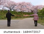 Small photo of Social distancing (6 feet / 2 meters) to avoid the spread of coronavirus (COVID-19). Two people stand apart holding two umbrellas. A new concept along with elbow bumping. New normal.