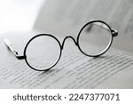 Reading glasses close-up on the pages of a book .Education and schooling concept.Symbol of study, knowledge and reading.