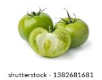 Whole and halved fresh green unripe tomatoes isolated on white background