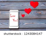 Love you! text on white phone with red hearts. The idea of communication with a loved one, declaration of love
