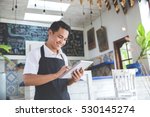 portrait of asian young male cafe owner with tablet