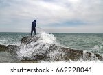 A Fisherman Stands On A Rock...