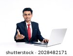Young indian man in suit and working on laptop at office