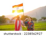 indian farmer couple saluting to national flag at agriculture field.