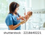 Small photo of Health care concept. Doctor neonatologist calming down a crying baby holding newborn infant baby girl in hospital. Medical checkup.