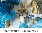 Small photo of A Newborn baby boy is given oxygen in the operating room immediately after caesarean section in hospital. Unrecognizable female doctor attends to a premature baby in a public maternity ICU.