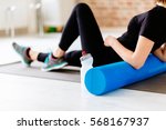 Fitness concept. Close up of woman relaxing after workout on the exercising mat.Portrait of Active Tired Woman Using Foam Roller in Light Room. 