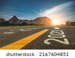2023 ,new year 2023 or beginning of 2023 word concept written on a road in the middle of a country road with mountains sunset concept backdrop.