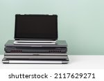 Small photo of Pile of old used laptop computers and digital tablet for recycling on white table. Planned obsolescence, e-waste, electronic waste for reuse and recycle concept