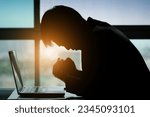 Small photo of Man sitting down, his face unsettled. At the computer desk he has headaches and stress. Cause of hard work and insufficient rest.