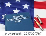 Law concept. On the US flag lies a pen and a book with the inscription - FREEDOM OF INFORMATION ACT - FOIA
