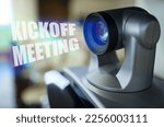 Small photo of Business and learning concept. A blue beam glows from the projector inside which is the inscription - Kickoff Meeting. In the background is a blurred meeting room