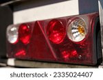 Close-up of the rear light of a truck semi-trailer with a damaged body. Road safety.