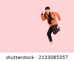 Happy handsome Asian man in fashionable clothing and jumping doing winner gesture isolated on pink background. Portrait of young male cheerful confident and excited jump in air and smile at studio.