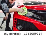 A man cleaning car with cloth, car detailing (or valeting) concept. Selective focus. 