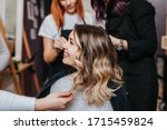 Beautiful hairstyle of young woman after dyeing hair and making highlights in hair salon.