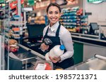 Small photo of Portrait of beautiful smiling cashier working at a grocery store.