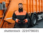 Small photo of Portrait of a young worker of the city utility company. Garbage collector.