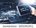 Technician diagnostics of code failure with OBD2 scanner technology on tablet in the auto repair garage