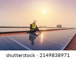Service Engineer use tablet working inspection installation solar cell on the roof. Technician maintenance solar cells on roof factory under morning sunlight. Technology solar energy renewable.