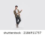 Full length smart young Asian man happy smile standing hand pointing to empty space on white background. Short on studio.