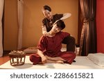 Asian man customer get service thai massage of neck stretching for treat painful from office syndrome with masseur in spa salon. Thai massage with masseur in spa salon.