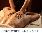 Small photo of Masseuse hand applying salt scrub on back customer at cosmetology spa centre. Relaxation man customer get service skincare scrubbing massage with masseuse in spa salon. Selective focus.