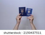 Small photo of The concept of changing citizenship. Repatriation. Law of Return. Women's hands holding an Israeli passport and a Ukrainian passport on a white background