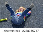 Small photo of The little boy is naughty. The child lies on the ground and cries, yells. Bad behavior, childish whims. The child wants a toy. The boy lifted his legs up, hysterical