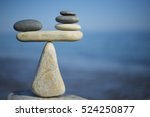 Balance of stones. To weight pros and cons. Balancing stones on the top of boulder. Close up. Balance of stones on a blue sky background with a copy space. Scales. Stones balance, sustainability.