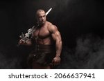 Small photo of Ferocious muscular ancient warrior barbarian with fantasy sword on black background