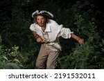 Small photo of Sea robber ship captain armed pirate goes through jungle. Concept historical halloween. Filibuster cosplay