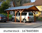 Small photo of New wooden Carport with Standing Seam Metal Roof in Front of a Residential Building
