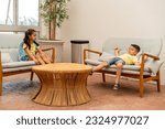Small photo of Relaxed Intermission. Two Schoolchildren Unwind and Talk on a Natural Sofa During a Lesson Break.
