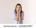 Small photo of Portrait of astounded preteen girl looking at camera. Surprised Caucasian child wearing blue T-shirt standing with open mouth. Awe and admiration concept