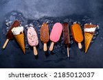 Set of various ice cream popsicle on black background. Assortment of icecream cones and popsicles on dark background top view flatlay copy space
