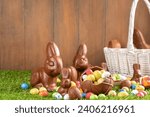 Small photo of Easter egg hunting background. Various candy and chocolate Easter eggs, bunny and rabbits with basket for eggs on green grass park or garden background