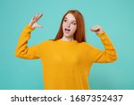 Small photo of Young redhead woman girl in yellow sweater posing isolated on blue turquoise background studio portrait. People emotions lifestyle concept. Mock up copy space. Showing blah blah gesture ja jaja hands