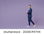 Small photo of Full size young successful employee business man lawyer 20s wear formal blue suit white t-shirt work in office move stroll hold use mobile cell phone isolated pastel purple background studio portrait