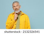 Small photo of Elderly wistful minded gray-haired mustache bearded man 50s wearing yellow shirt look aside on workspace area mock up isolated on plain pastel light blue background studio. People lifestyle concept