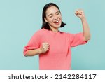 Small photo of Young overjoyed happy excited woman of Asian ethnicity 20s wear pink sweater do winner gesture celebrate clenching fists say yes isolated on pastel plain light blue color background studio portrait.
