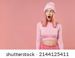 Small photo of Young shocked amazed woman 20s with bright dyed rose hair wearing rosy top shirt hat look aside isolated on plain light pastel pink color background studio portrait People lifestyle fashion concept
