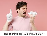 Small photo of Sick unhealthy ill allergic man has red watery eyes runny stuffy sore nose suffer from allergy trigger symptoms wear white dirty glove with dust on hand isolated on pastel pink color background studio