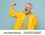 Small photo of Elderly happy gray-haired mustache bearded man 50s wear yellow shirt doing winner gesture celebrate clenching fists say yes isolated on plain pastel light blue background. People lifestyle concept.