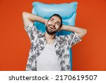 Young tourist man with spf sunscreen cream on wear beach shirt lies on blue inflatable mattress hotel pool look overhead isolated on plain orange background. Summer vacation sea rest sun tan concept