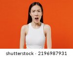 Small photo of Astonished impressed aggrieved disconcerted mazed young woman of Asian ethnicity 20s years old in white tank top looking camera keep mouth wise open isolated on plain orange background studio portrait
