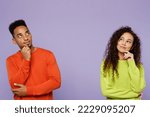 Small photo of Young minded thoughtful couple two friends family man woman of African American ethnicity wear casual clothes together prop up chin look aside on area isolated on pastel plain light purple background