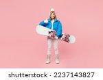 Full body snowboarder woman wear blue suit goggles mask hat ski padded jacket snowboard show thumb up isolated on plain pastel pink background. Winter extreme sport hobby weekend trip relax concept